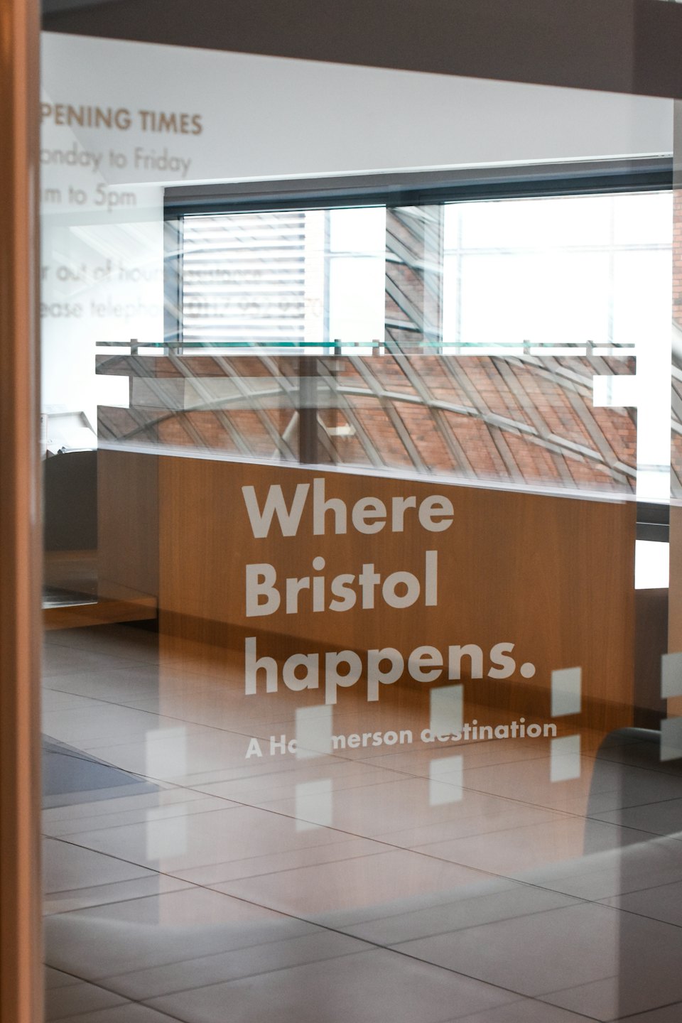 White lettering on a glass door reflects a modern office.